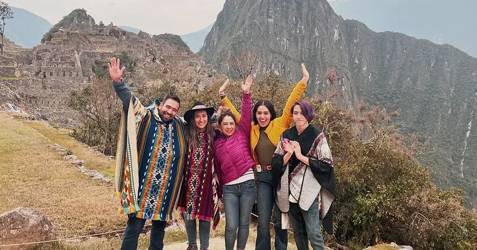 Amigos posando para uma foto ao fundo, montanha Machu Picchu e sítios arqueológicos ao fundo