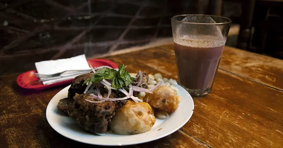 Refeição típica de carne de porco com batata e milho com morango, comida tradicional nos restaurantes picantes de Cusco