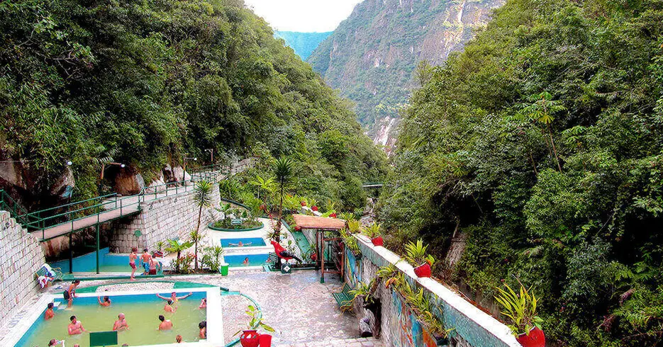 Fontes termais da cidade de Aguas Calientes, cercadas por árvores e montanhas