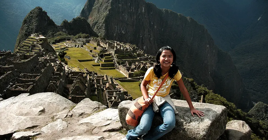 Menina feliz em Machu Picchu, uma das 7 maravilhas do mundo moderno