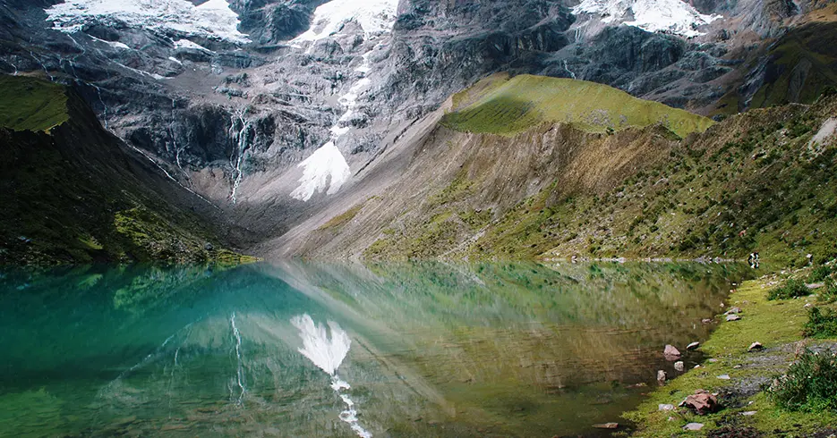 Lagoa Humantay em Cusco, lagoa azul-turquesa e cristalina com muita vegetação verde ao redor