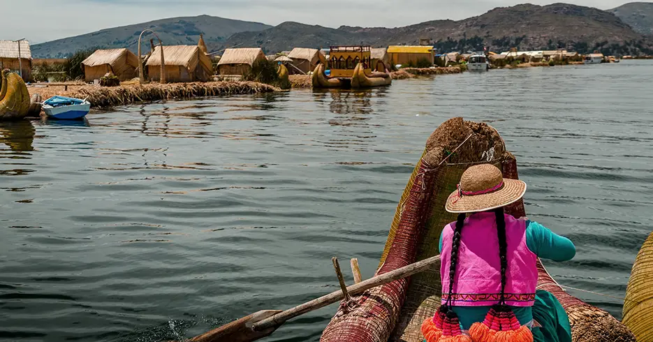 Mulher dirigindo um barco totora no Lago Titicaca em Puno