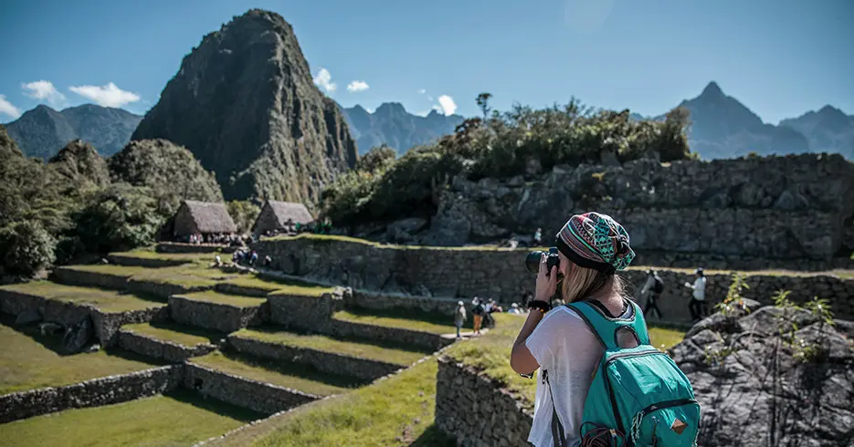 Turista fotografando a praça principal de Machu Picchu