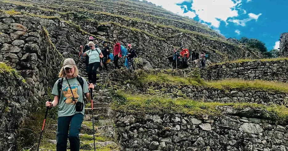 Trilha Inca para Machu Picchu com várias pessoas descendo com seus bastões de caminhada fazendo o trekking