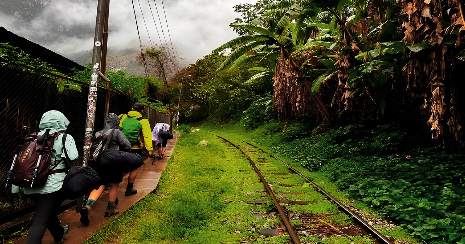 Hikers walking beside the railway during the Salkantay Trek to Machu Picchu