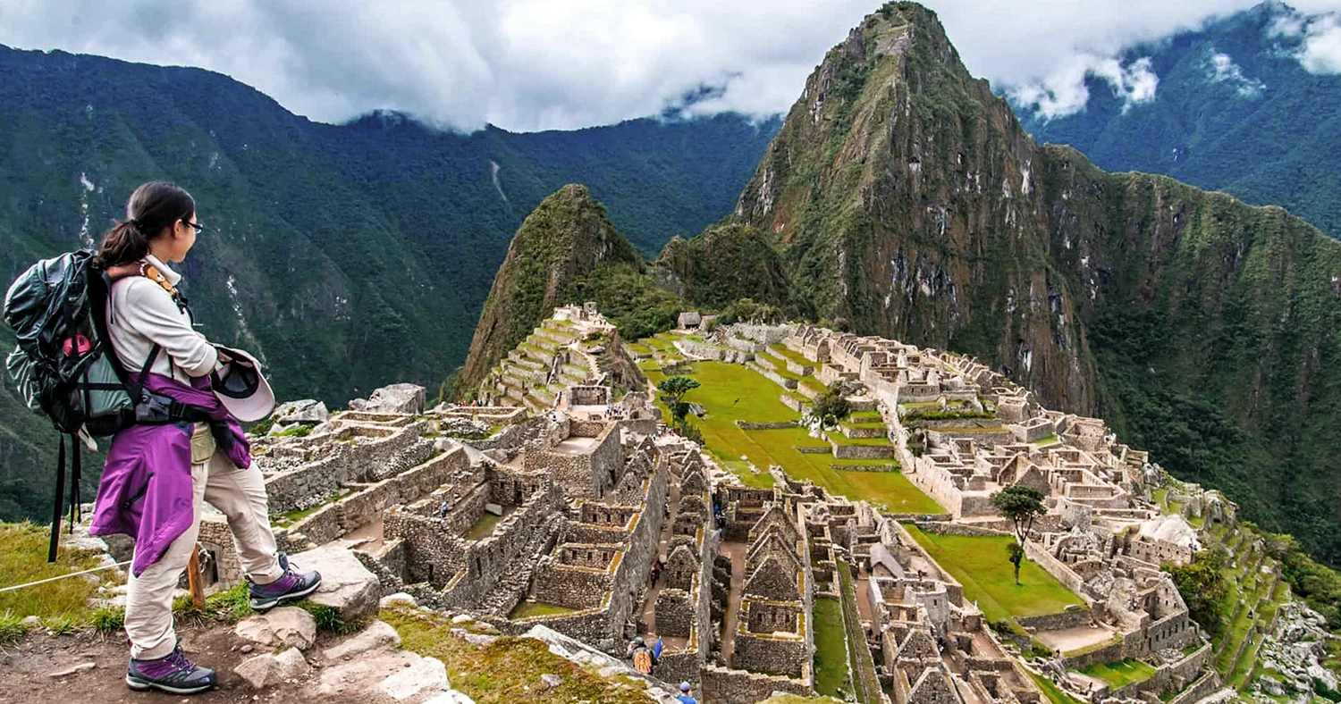 Traveler overlooking the Machu Picchu Inca citadel in Peru