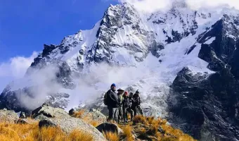 Hikers walking toward snow-covered mountains on the Salkantay Trek in Peru
